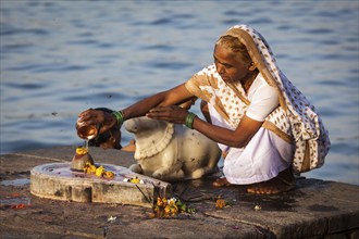 MAHESHWAR, INDIA, APRIL 26: Indian woman performs morning pooja on sacred river Narmada ghats on