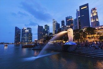 SINGAPORE, JANUARY 1, 2014: Night view of Singapore Merlion at Marina Bay against Singapore skyline