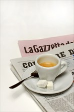 Cup of espresso with sugar on newspaper, household sugar, sugar cubes, coffee