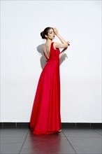 Charming girl in waiving red silk dress with straps