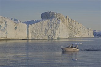 Small boat in front of icebergs, midnight sun, Ilulissat, Disko Bay, Denmark, Greenland, North