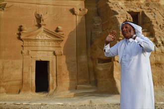 Rawi, storyteller, in front of the Nabataean tombs at the rock Qasr Al-Bint, Hegra or Madain Salih,