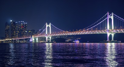 Gwangan Bridge and skyscrapers illuminated in the night. Busan, South Korea, Asia