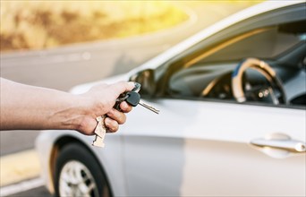 Driver hands showing the keys outside the vehicle, Vehicle rental concept. Close-up of driver