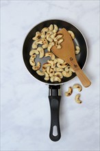 Cashew, roasted cashew kernels in pan with ladle