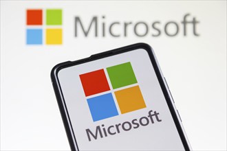 Microsoft logo of the software company on a mobile phone and computer screen