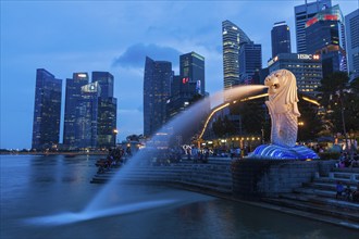 SINGAPORE, JANUARY 1, 2014: Night view of Singapore Merlion at Marina Bay against Singapore skyline