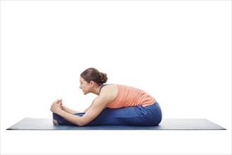 Sporty fit woman doing Ashtanga Vinyasa yoga back bending asana Paschimottanasana, seated forward