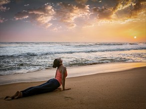 Yoga outdoors, woman doing Ashtanga Vinyasa yoga Surya Namaskar Sun Salutation asana Urdhva Mukha