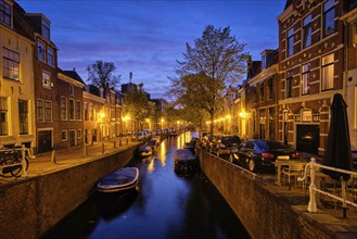 Typical Netherlands view, canal with boats and houses illuminated in the evening. Haarlem,