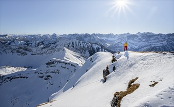 Ski tourers at the summit of Schafreuter, view of snowy mountain panorama, Karwendel, Tyrol,