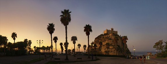 Parking with palm trees overlooking the medieval church Santuario di Santa Maria dell Isola di