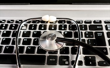 Stethoscope on laptop keyboard. Online medical consultation concept