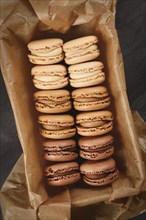 Brown, beige and cream colored French macarons with coffee, mocha, chocolate and vanilla flavor in