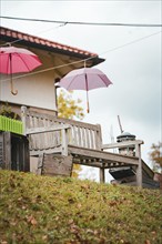 Bench with hanging umbrellas in autumn, Bad Wildbad, Black Forest, Germany, Europe