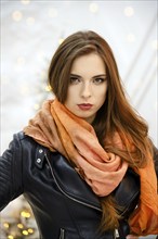 Classy woman in orange silk headscarf wrapped around her head looks strict