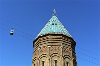 Two cabins of the Rike-Narikala cable car pass the tower of St George's Armenian Church, Tbilisi,