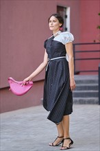 Cute fashionable lady in long striped dress descending the stairs