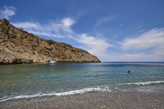 Menies, Rodopou, dream bay, pebble beach, single boat, person in the water, crystal clear sea,