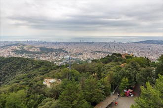 View of the sea of houses up to the coast, cloudy sky in autumn, haze, Tibidabo, Barcelona, Spain,