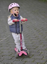 Little girl, 2 years, blond, helmet, pink, rides scooter, scooter, Stuttgart, Baden-Württemberg,