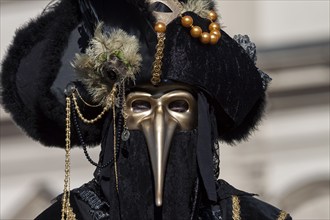 Beak mask, plague mask, mask wearer at the Venetian fair on the historic market square,