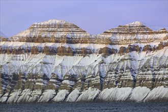 Snow covered Carboniferous mountain slope showing strata in autumn, Billefjord, Billefjorden,