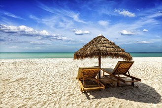 Vacation holidays background wallpaper, two beach lounge chairs under tent on beach