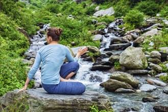 Yoga exercise outdoors, woman doing Ashtanga Vinyasa Yoga asana Marichyasana D seated spinal twist