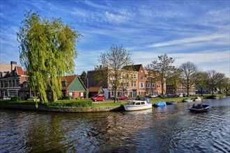 HAARLEM, NETHERLANDS, MAY 6, 2017: Boat in canal and houses. Harlem, Netherlands