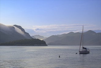 Sailing ship and morning fog over the mountains, Trstenik, Dubrovnik-Neretva County, Croatia,