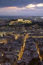 View over the sea of houses of Athens, illuminated Parthenon temple on the Acropolis, dramatic