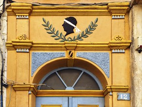 Colourful house entrance, decorated front door, black head with white headband, traditional symbol