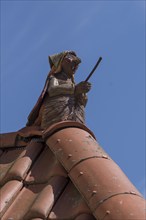 Figure of a witch on the roof ridge of a residential house, blue sky, Zeil am Main, Lower