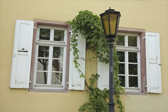 Street lamp and house wall with two shutters, overgrown, window, Palais Verna, Verna-Park