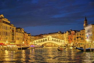 Famous Venetian tourist landmark Rialto bridge (Ponte di Rialto) over Grand Canal illuminated at