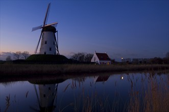 The traditional windmill Schellemolen at sunset along the Damme Canal, Damme, West Flanders,