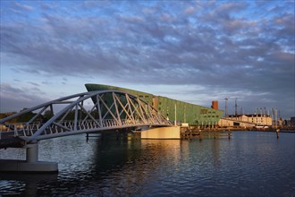 AMSTERDAM, NETHERLANDS, MAY 9, 2017: NEMO Science museum and Mr. J. van der Veldebrug bridge. It is