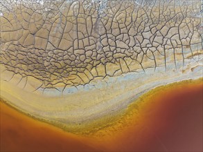 Cracked earth at the bank of the Rio Tinto (Red river) with its deep reddish hue due to oxidised