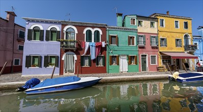 Colourful houses on the canal with reflection, Canal with boats and colourful house facades, Burano