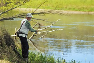 Fisherman trying to do a perfect cast, throwing lure. Spining fishing, angling, catching fish.