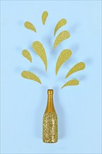 Golden splashing Champagne bottle on blue background