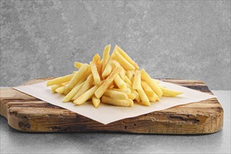 Portion of salty french fries on paper