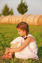 Girl sitting in a meadow in summer