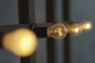 Old edison lamp mounted on wooden background