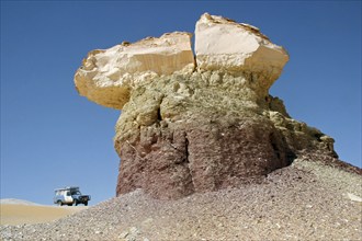 Four-wheel drive vehicle and limestone rock formation in Egypt's White Desert, Sahara el Beyda near