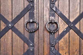 Weathered wood door with handles and iron bars