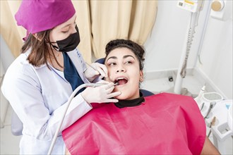 A dentist cleaning a patient mouth with a drill. Stomatologist cleaning a patient's teeth, Close-up