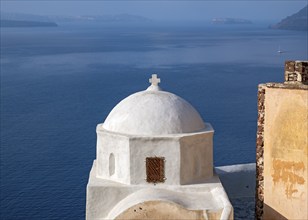 White-washed Agios Nikolaos Castle Church with blue sea in background, Ia, Oia, Santorini, Thira,