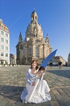 Stollen girl Lisa Straßberger presents the giant stollen knife in front of the Church of Our Lady